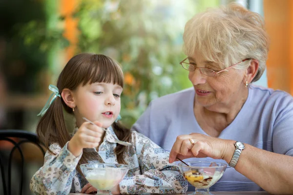 おいしいアイスクリームを一緒に食べる孫娘とシニアの祖母 — ストック写真