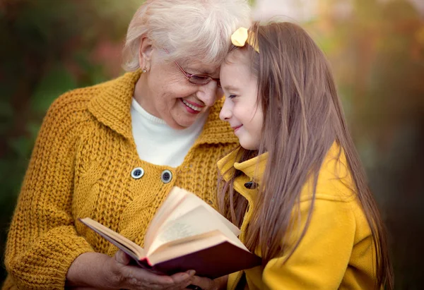 Babcia Wnuczką Czytania Książki Jesienny Park — Zdjęcie stockowe