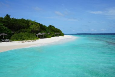 Maldivler 'in Baa Mercan bölgesinde mavi gökyüzünün altında güzel turkuaz deniz ve tropikal kumlu plaj