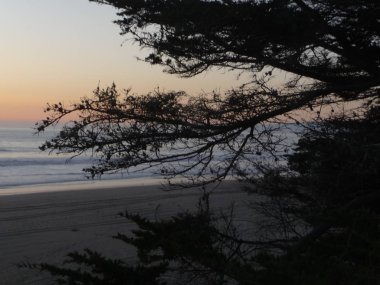 Kaliforniya kıyıları boyunca dalgalı ve bulutlu gökyüzü ile muhteşem okyanus manzarası