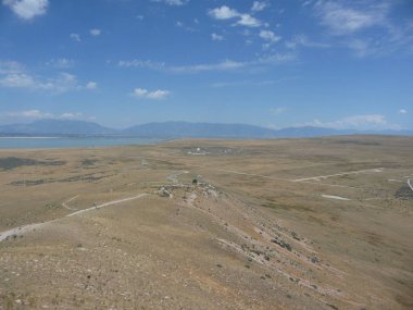Utah 'taki Büyük Tuz Gölü boyunca uzak tepeleri ve mavi gökyüzü olan çöl manzarası.
