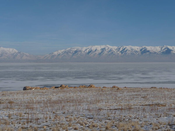 View of snow-capped land with distant mountains along the Great Salt Lake, Utah