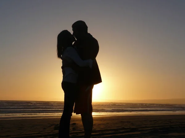 Σιλουέτα Του Ζευγαριού Στέκεται Και Φιλιά Από Θάλασσα Στο Ηλιοβασίλεμα — Φωτογραφία Αρχείου