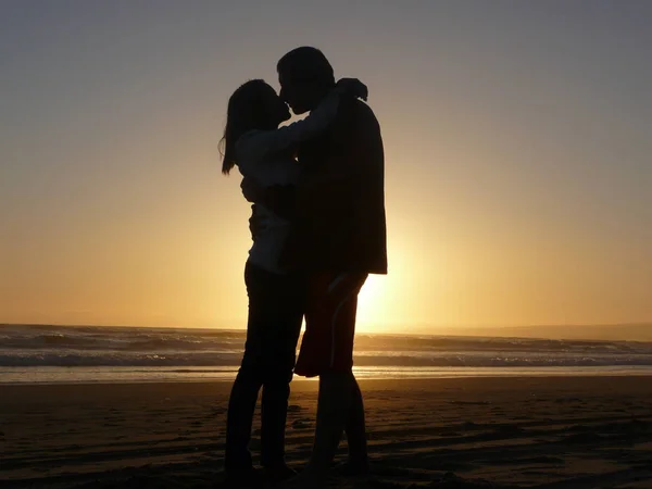 Silhouette Eines Paares Das Bei Sonnenuntergang Meer Steht Und Sich — Stockfoto