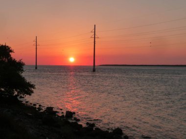 gün batımında elektrik telleri ile deniz manzara