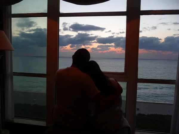 Pareja Abrazándose Por Ventana Con Vista Atardecer —  Fotos de Stock