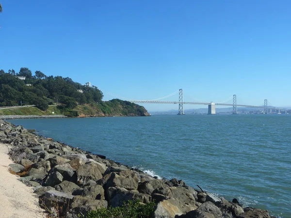 日当たりの良い海洋風景の橋を持つ岩の海岸 — ストック写真