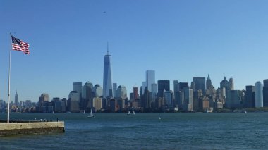 ön planda mavi gökyüzü ve ABD bayrağı ile New York şehir silueti