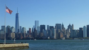 ön planda mavi gökyüzü ve ABD bayrağı ile New York şehir silueti