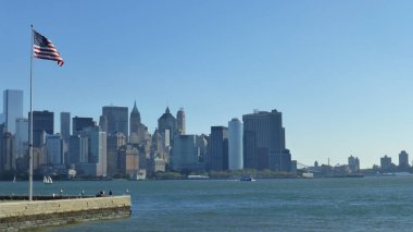 ön planda mavi gökyüzü ve ABD bayrağı ile New York şehir silueti