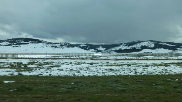 Зелене Поле Снігом Далекими Пагорбами Під Хмарним Небом — стокове фото