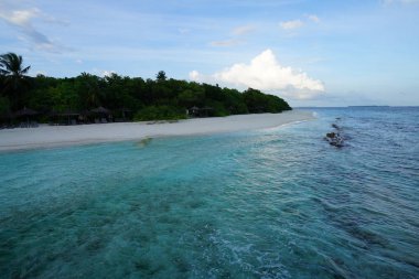 kumlu plaj şemsiyeleri ve temiz su üzerinde avuç içi ile görünümünü