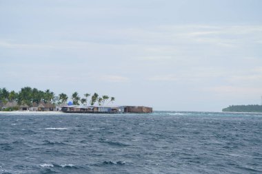 deniz üzerinde kıyıda otantik kulübeve yeşillik uzak görünümü