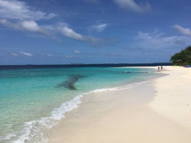 mavi lagün kumlu plaj uzak yürüyen insanlarla