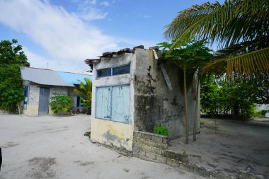 mavi bulutlu gökyüzü altında tropikal yeşillik ile döken binalar