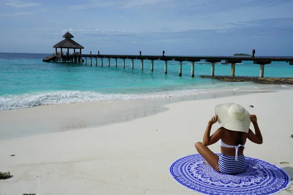 坐在沙滩上戴帽子的妇女 — 图库照片
