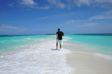 arkadan görünüşü dalgalar mavi defne üzerinde yürüyen adam