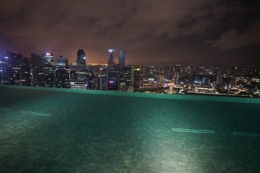 Singapur binalar ve geceleri ışıklı otel çatı havuzu