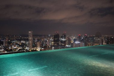 Singapur binalar ve geceleri ışıklı otel çatı havuzu