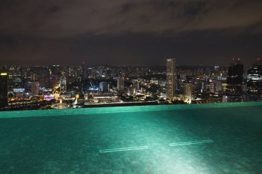Singapur binalar ve geceleri ışıklı otel çatı havuzu
