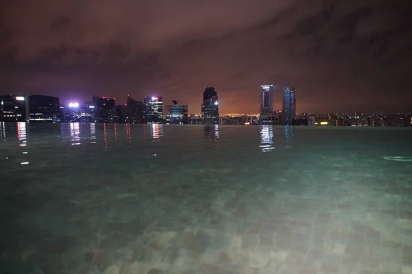 シンガポールの建物やホテル屋上プール夜ライトアップ — ストック写真