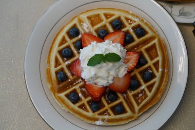 çilek ile lezzetli waffle bölümünü, krem ve nane yaprakları