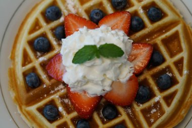 çilek ile lezzetli waffle bölümünü, krem ve nane yaprakları