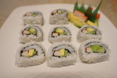 Suşi avokado ve yengeç bölümünü tabakta