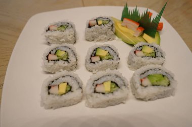 Suşi avokado ve yengeç bölümünü tabakta