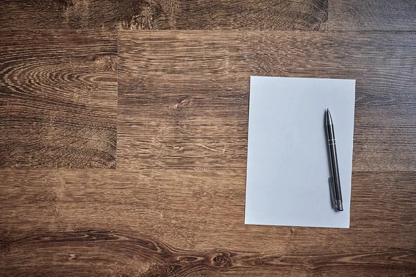 notebook with pen on wood background