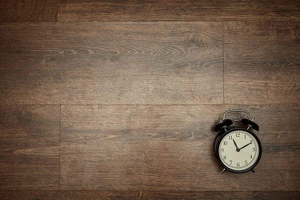 Reloj puntero sobre fondo de madera — Foto de Stock