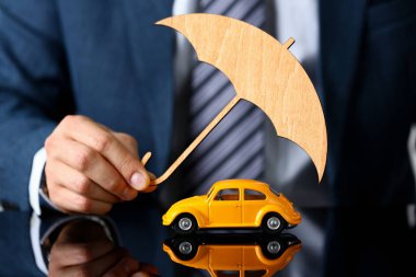 Takım elbiseli iş adamı şemsiye tutuyor.