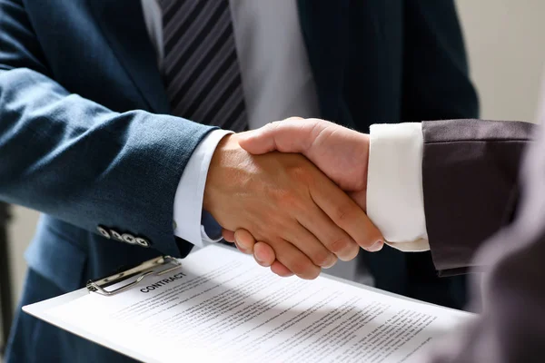 Man in suit shake hand as hello in office closeup