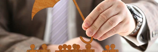 Businessman holds wood umbrella in hand — Stock Photo, Image