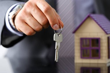 Erkek takım elbise ve kravat tutun el Gümüş anahtar veriyorum