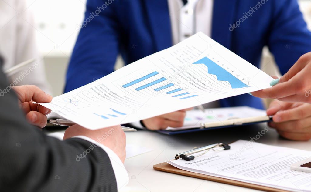 Group of people discuss financial results at workplace