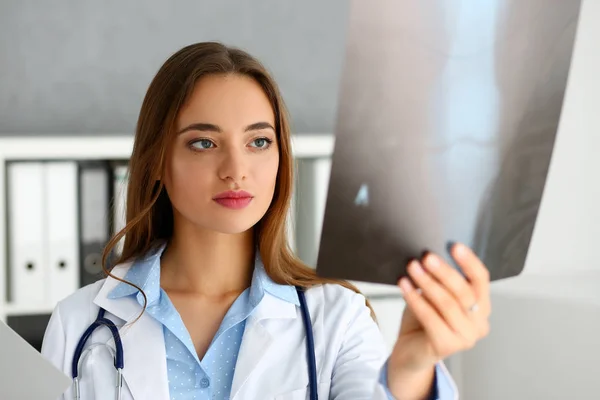Krásný ženský lékař držet v ruce a podívat — Stock fotografie