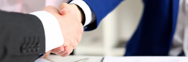 Man in suit shake hand as hello in office closeup