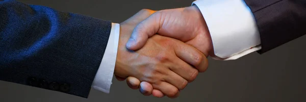 Man in suit shake hand as hello in office closeup