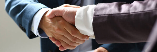 Man in suit shake hand as hello in office closeup