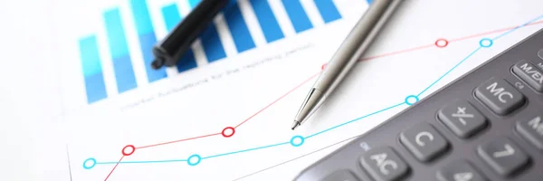 Silver calculator and financial statistics on clipboard pad at office table closeup. Internal Revenue Service inspector sum check irs investigation earnings savings loan and credit concept