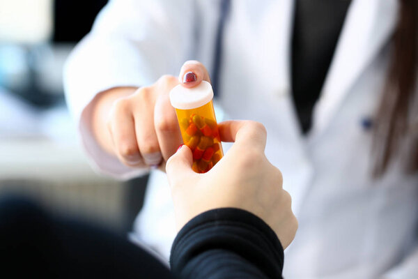 Female medicine doctor hand hold jar of pills and