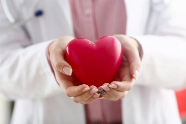 Kadın doktor kollarında tutun ve kırmızı oyuncak kapak