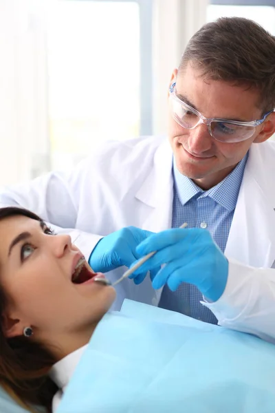 Woman at the reception of a male dentist examining teeth — Stock Photo, Image