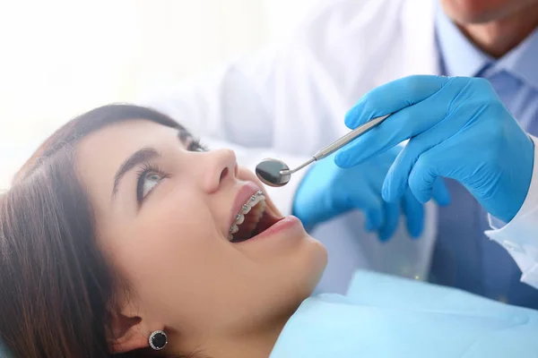 Femme à la réception d'un dentiste masculin examinant les dents — Photo