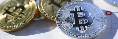Gümüş ve altın bitcoin kağıt grafik üzerinde