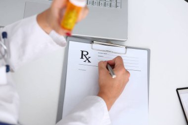 Kadın doktor el kavanoz hapları tutun ve reçete yazmak