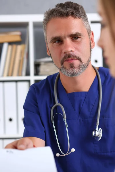 Médico de raza masculina en uniforme azul mantenga y dé prescripción — Foto de Stock