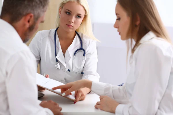 Female family doctor listen carefully young couple