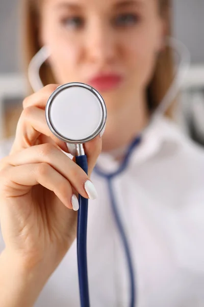 Hermosa mujer sonriente médico mantenga en el brazo la cabeza del estetoscopio — Foto de Stock